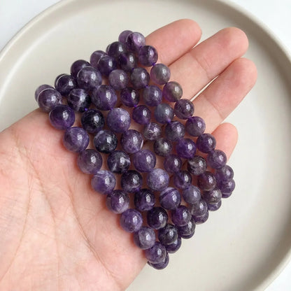 Natural amethyst beads shown in hand for size comparison