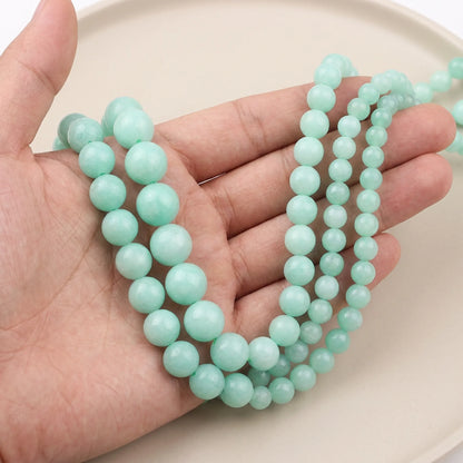 Natural blue amazonite beads shown in hand for size comparison