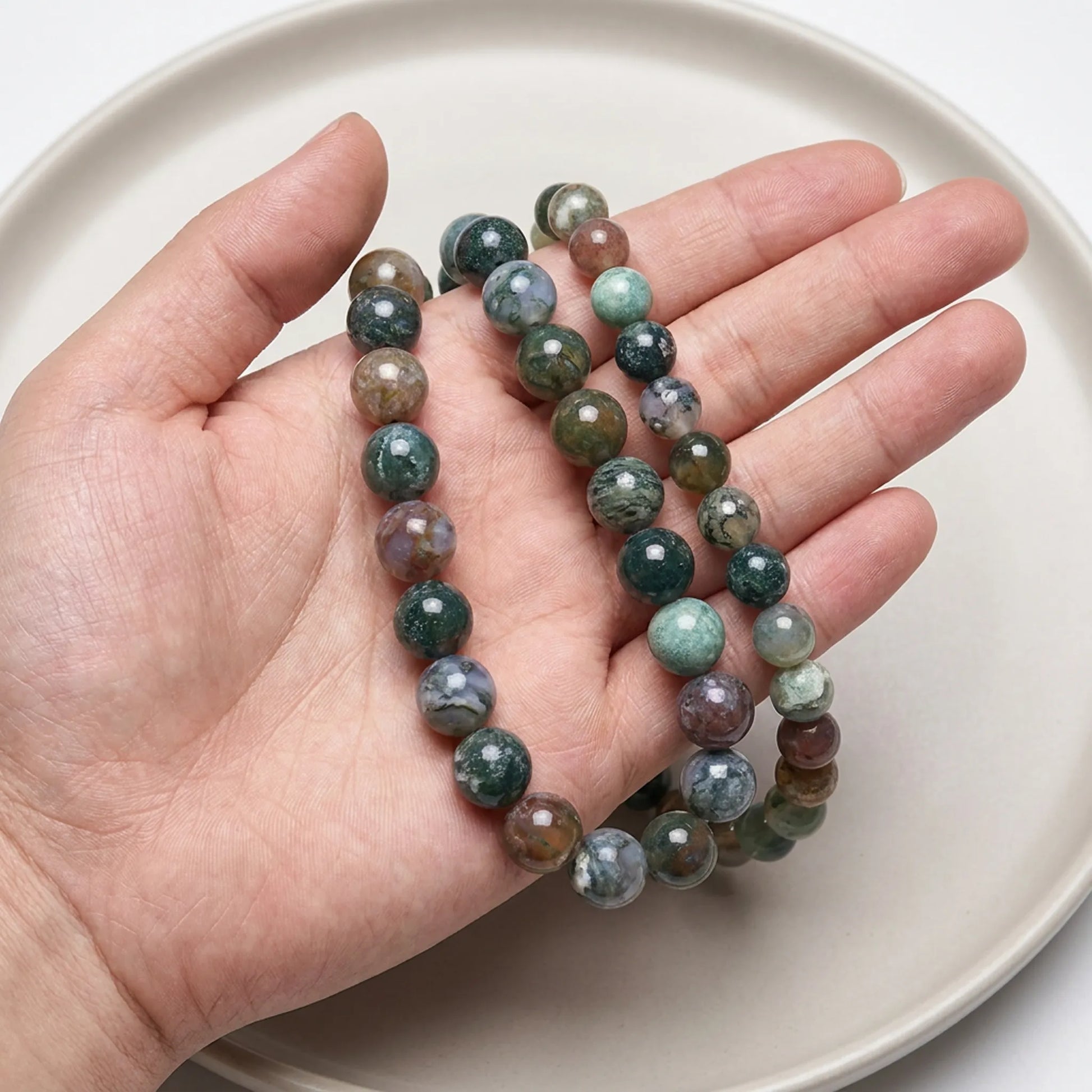 Natural Indian agate beads shown in hand for size comparison