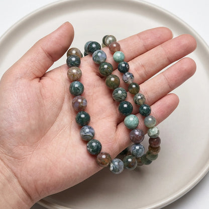 Natural Indian agate beads shown in hand for size comparison