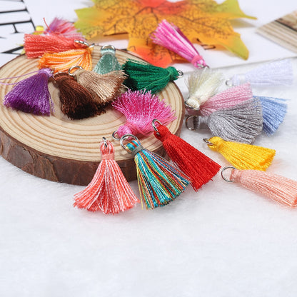10 à 20 pendentifs à petits pompons en coton de 2 cm.