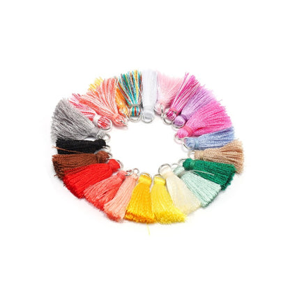 10 à 20 pendentifs à petits pompons en coton de 2 cm.